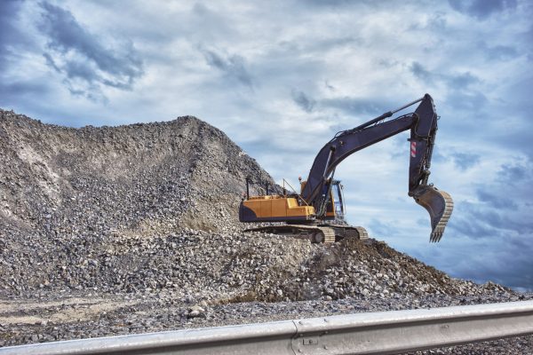 Excavator and mound of construction material